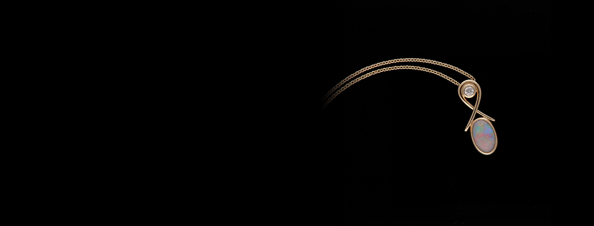 A gold, diamond and opal necklace with a stylised pendant